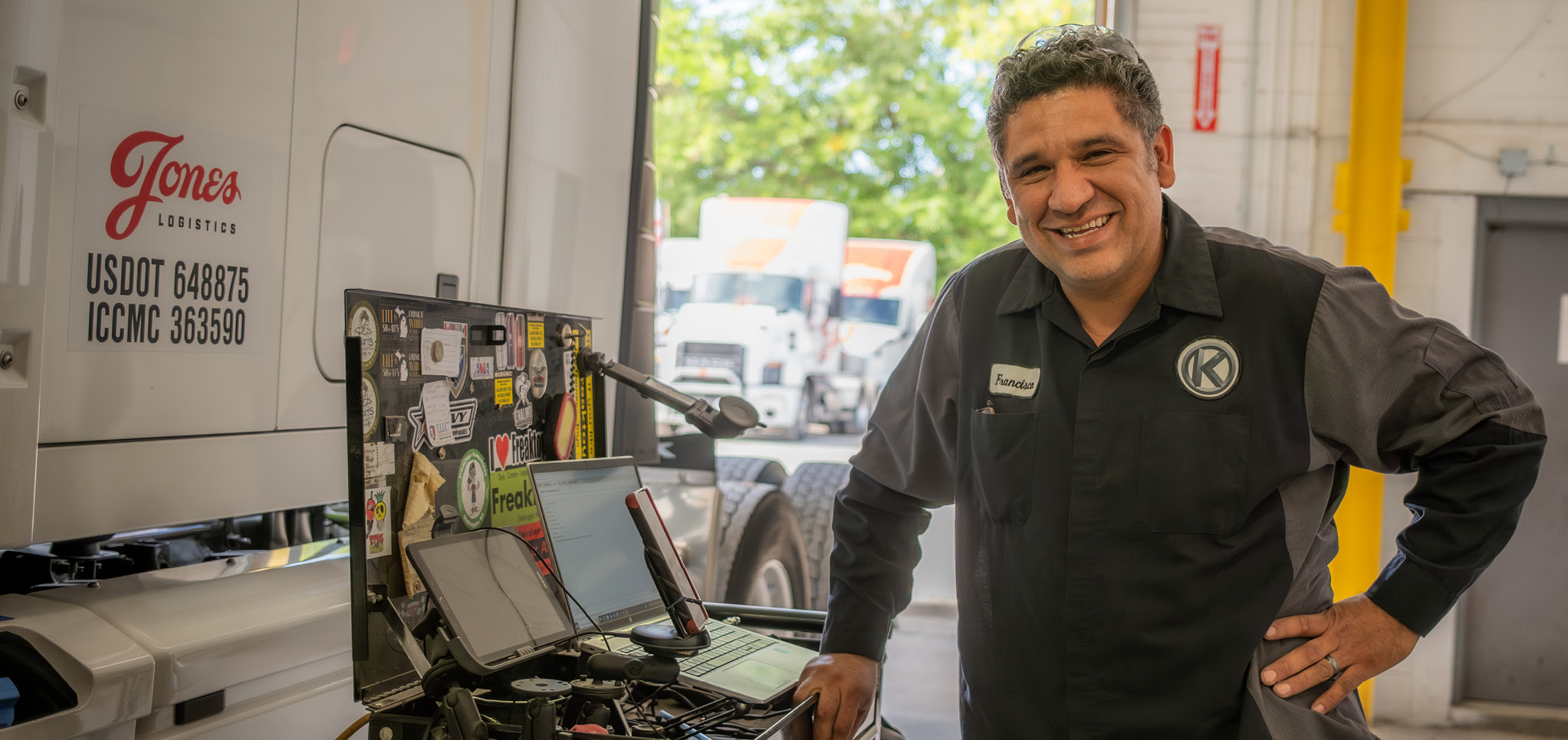 Jones Logitics employee Francisco Nunez smiling at the camera while working with computer equipment