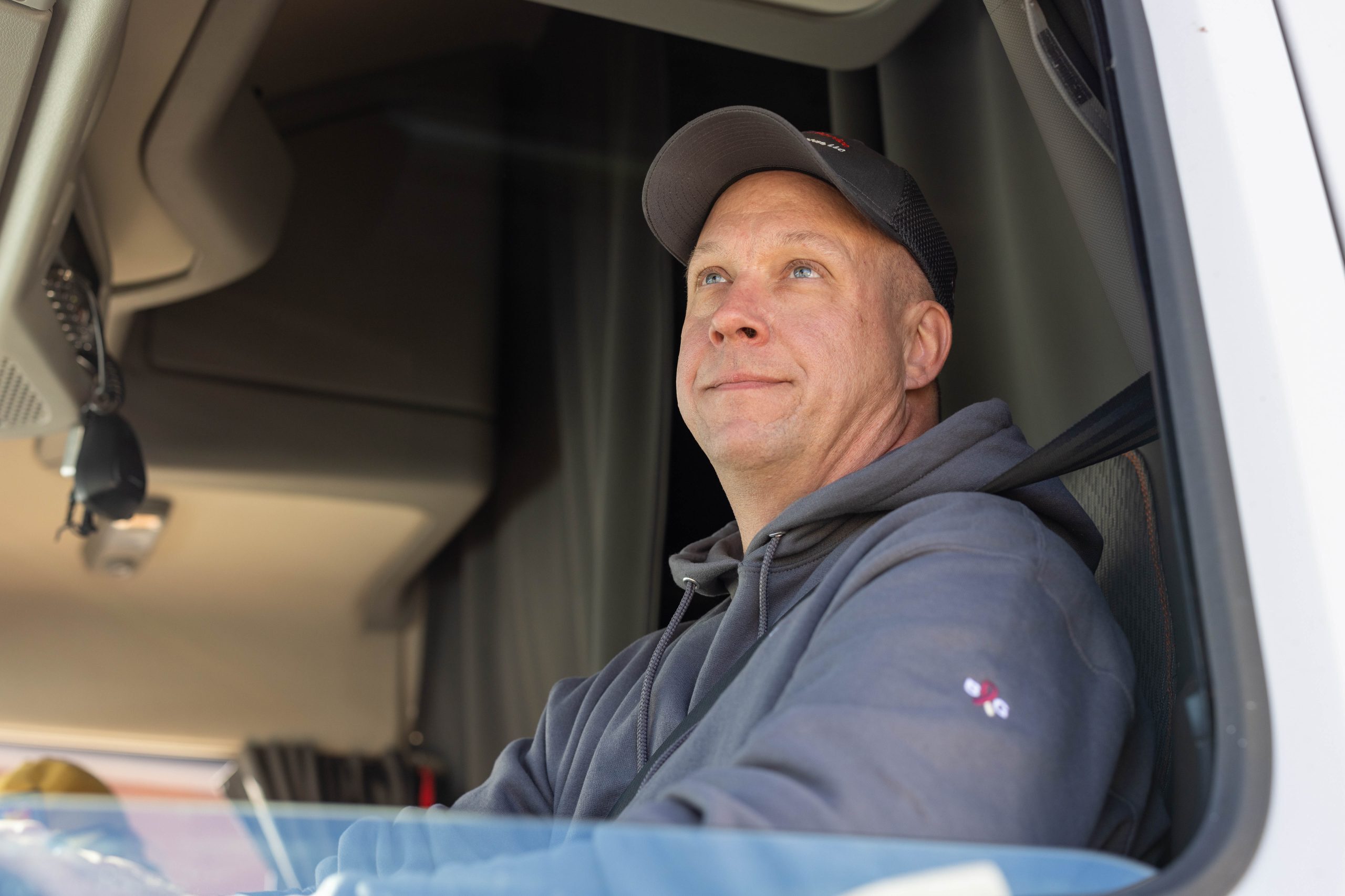 Legacy-Express driver Mark Schneweis in a gray hoodie and cap looking out of the driver-side window