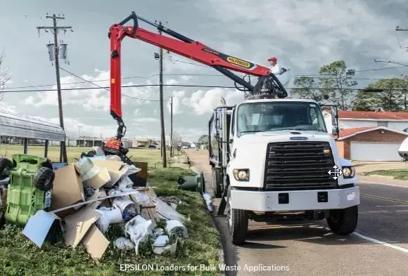 A Palfinger loader collecting refuse from the side of the road