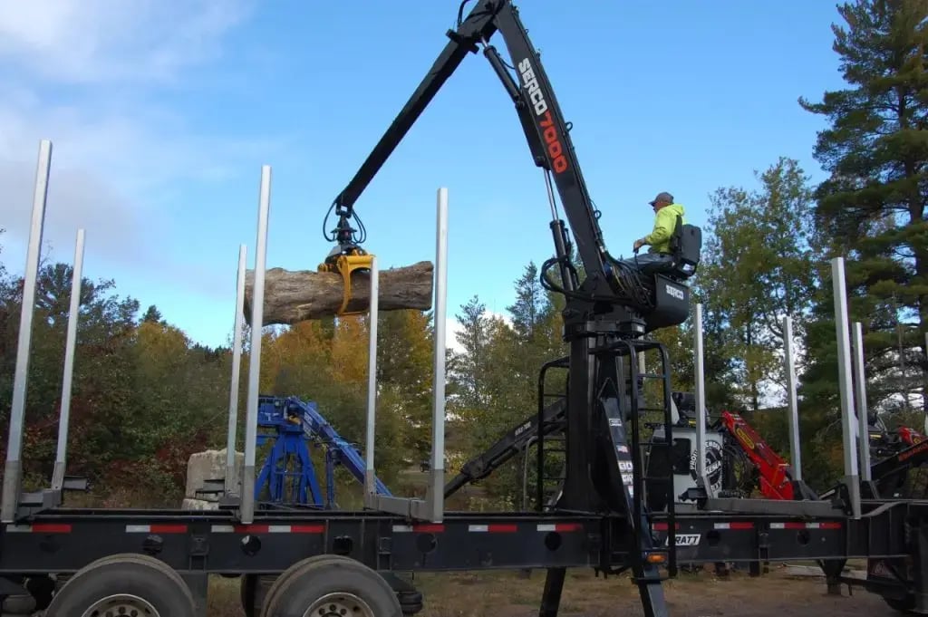 A Serco 7000 trailer-mounted loader moving timber