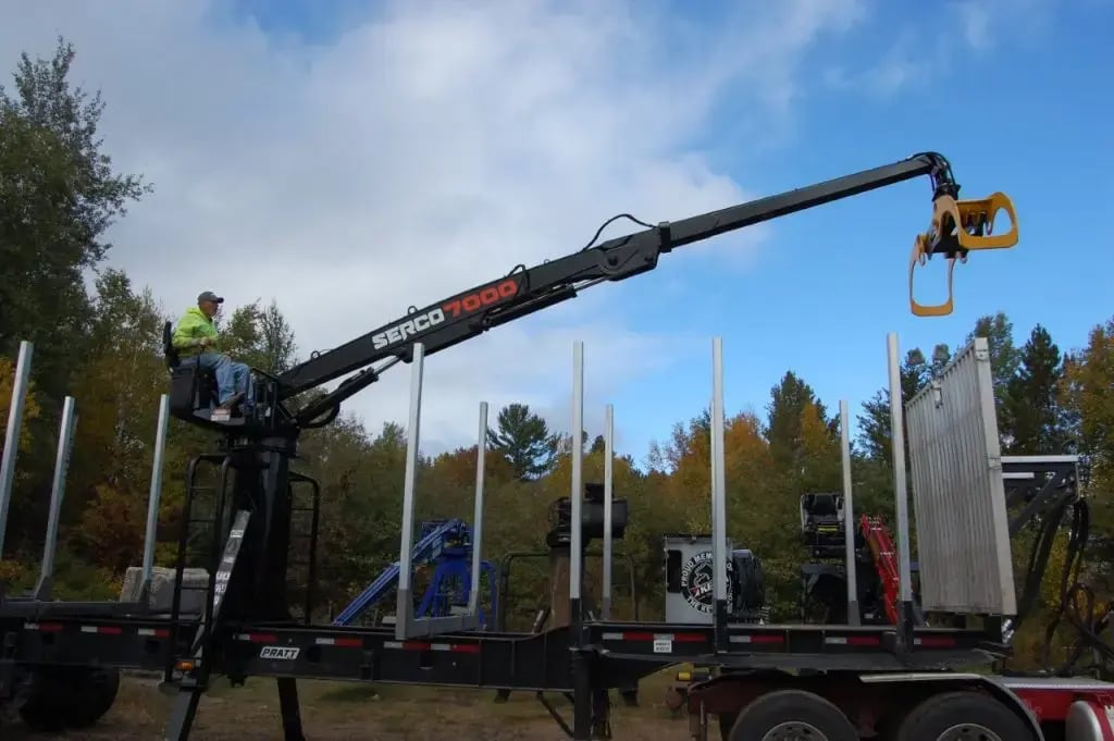 A Serco 7000 knuckleboom loader in operation