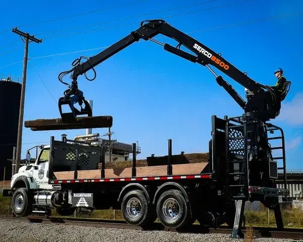 Serco 8500 series loader transferring wooden beams onto a truck bed