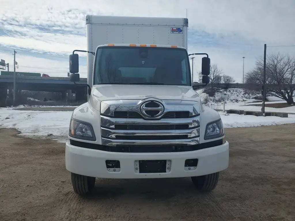 White Hino L6 truck in a snowy car park, front-on