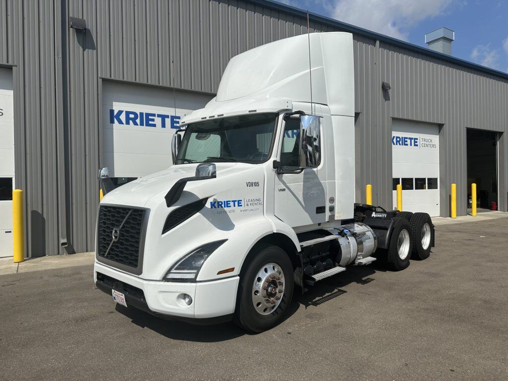 A white, Kriete-branded Volvo truck parked in front of a Kriete warehouse