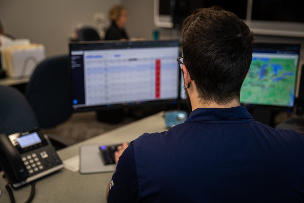 Over-the-shoulder shot of a Kriete employee sitting in front of a computer monitor at his desk