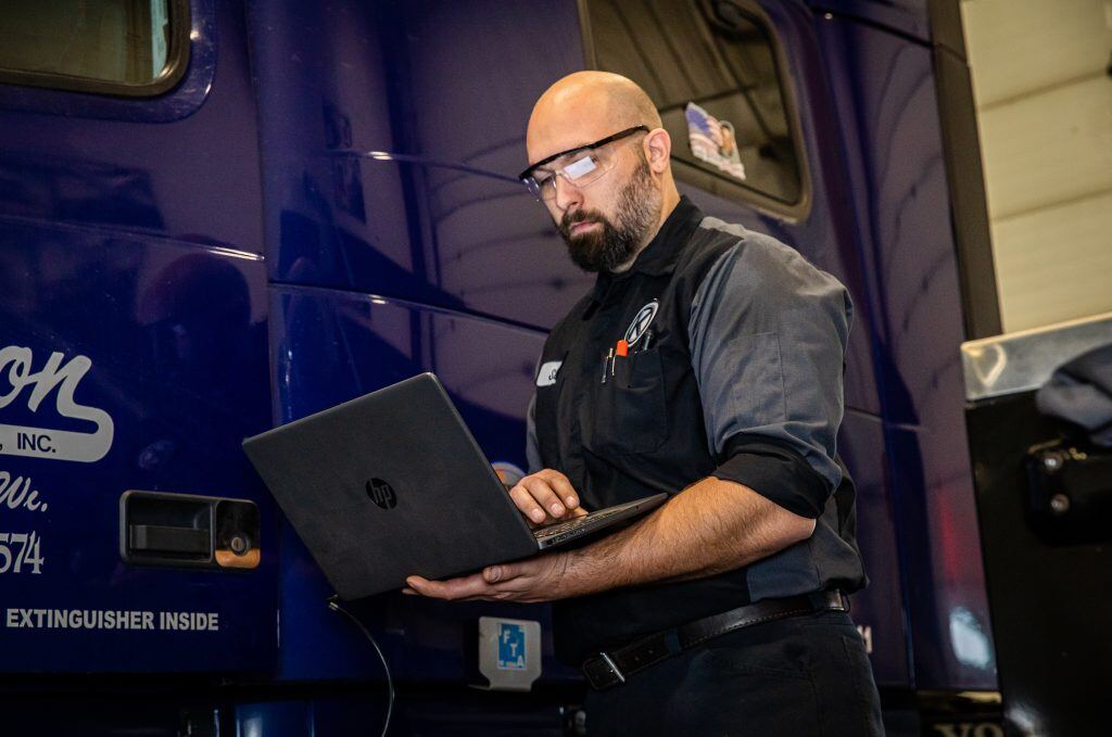 Kriete technician in black and gray overalls performing an oil analysis