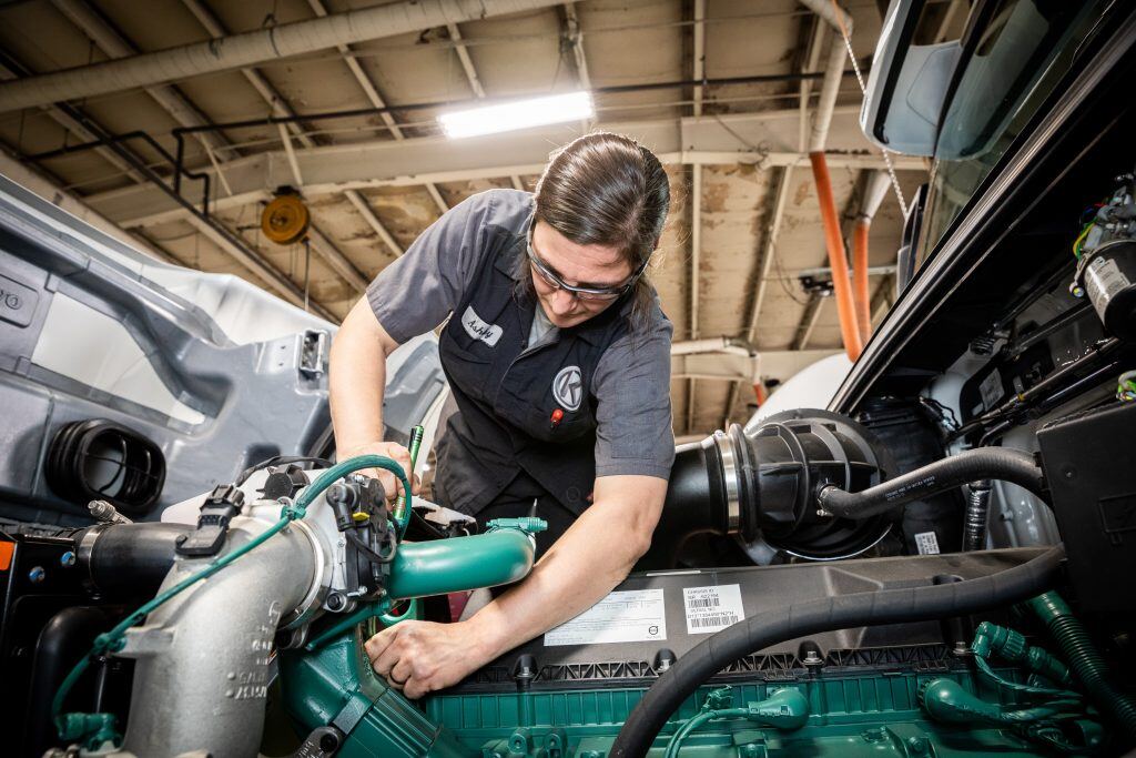 Kriete technician in a gray shirt working on an engine
