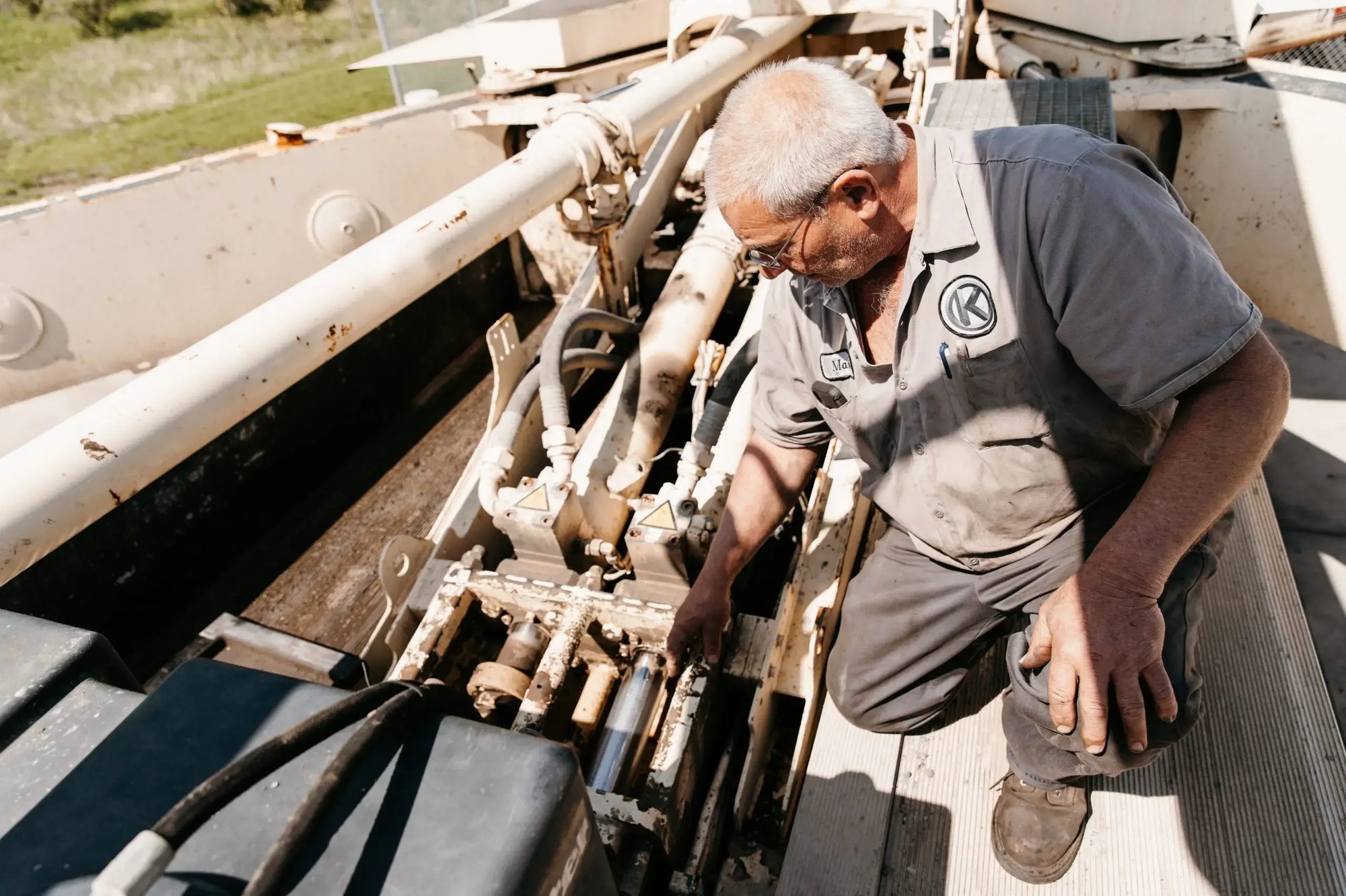 Mark Kelemen on top of a truck, inspecting a boom mechanism