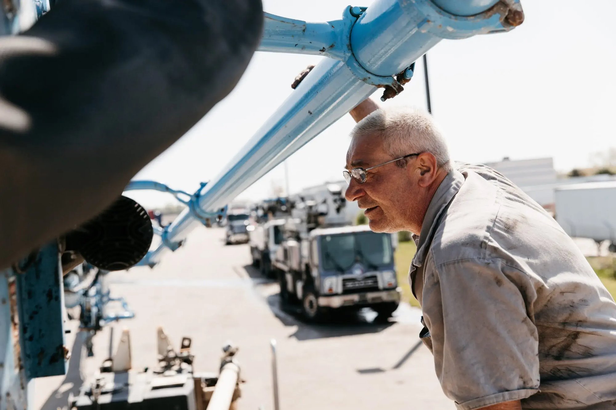 Mark Kelemen leaning in to inspect the a boom mechanism