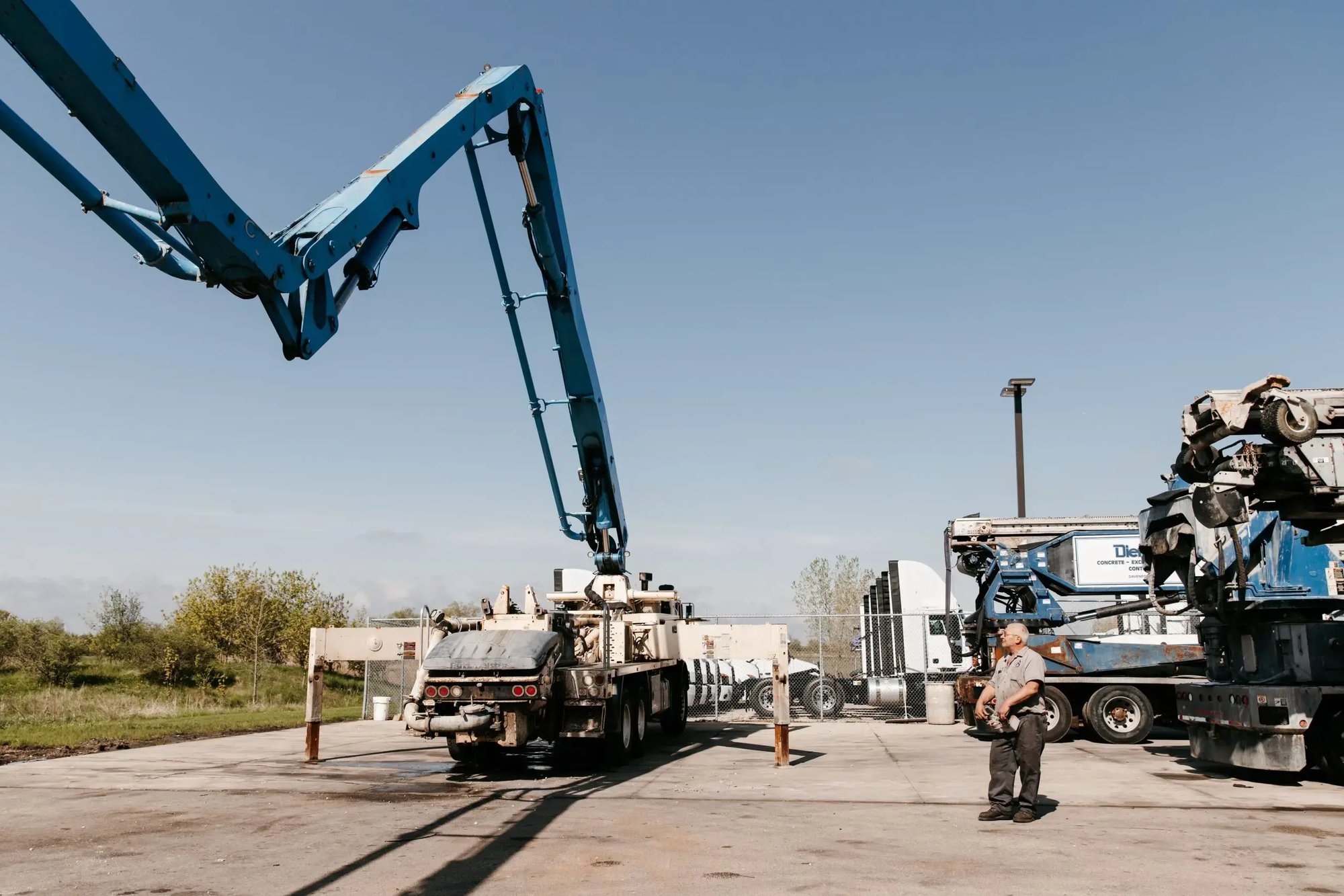 Wide-angle shot of Mark Kelemen inspecting a boom extending from an off-white truck