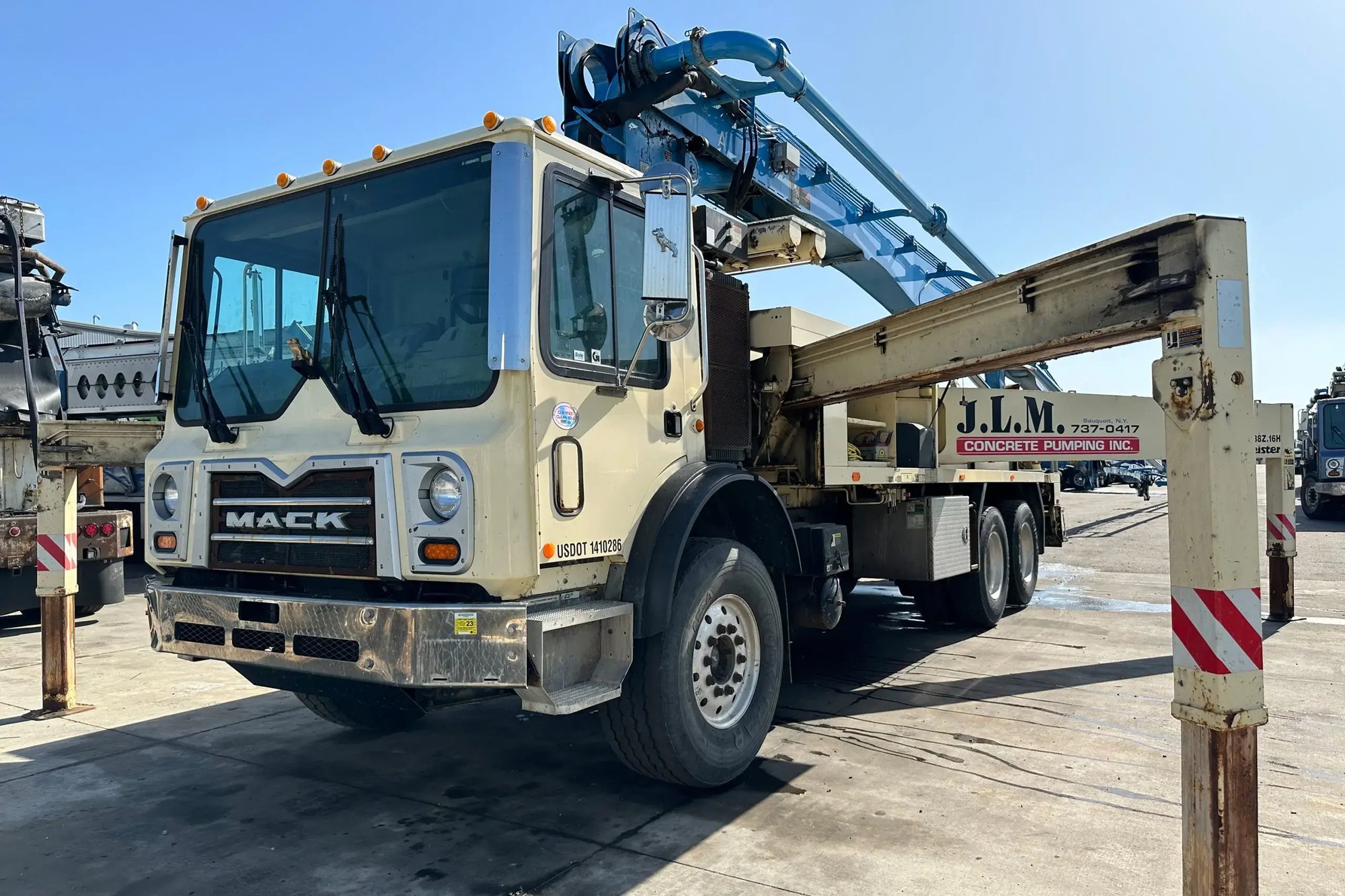 An off-white Mack truck undergoing a boom inspection