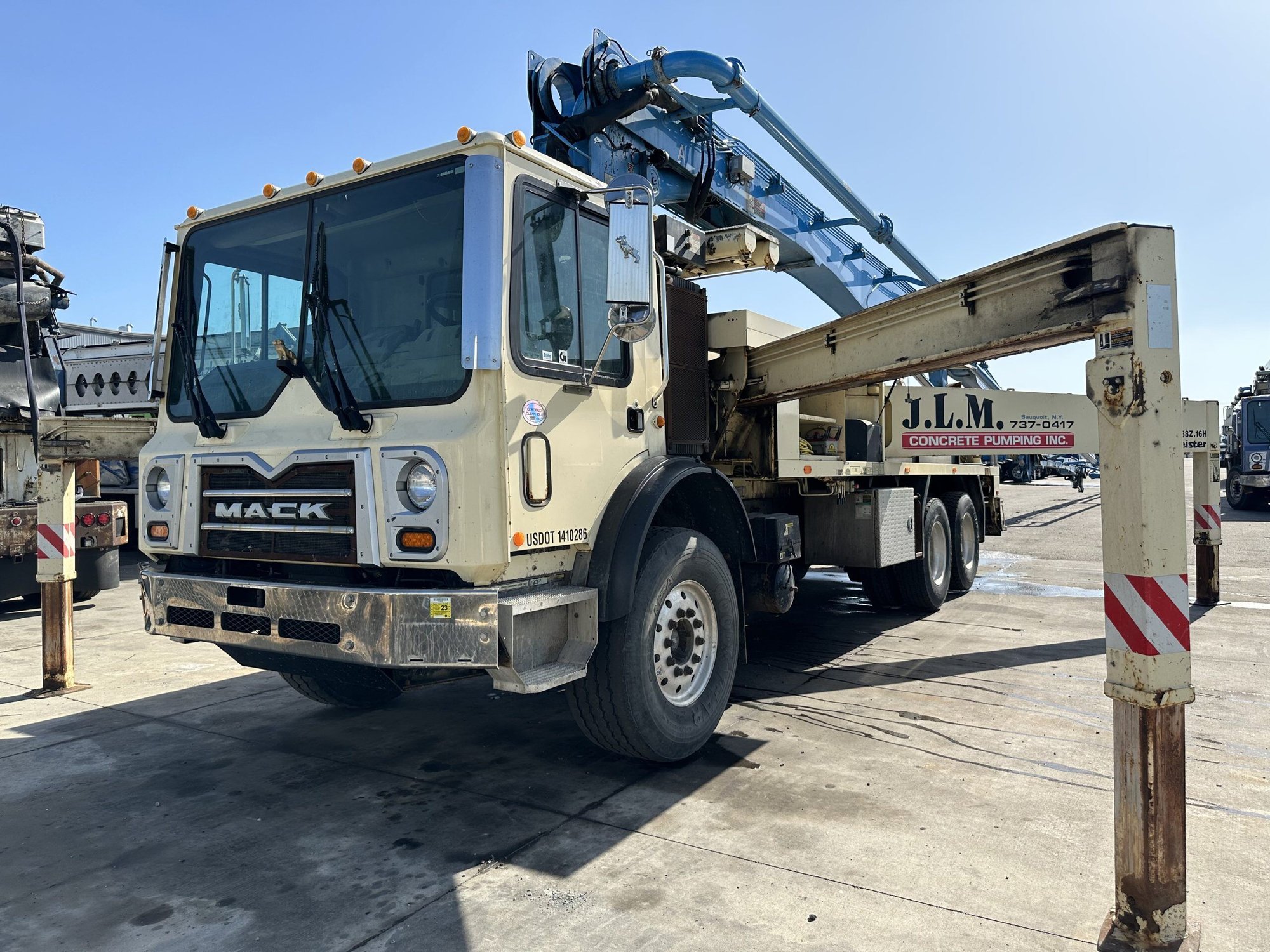 An off-white Mack truck undergoing a boom inspection