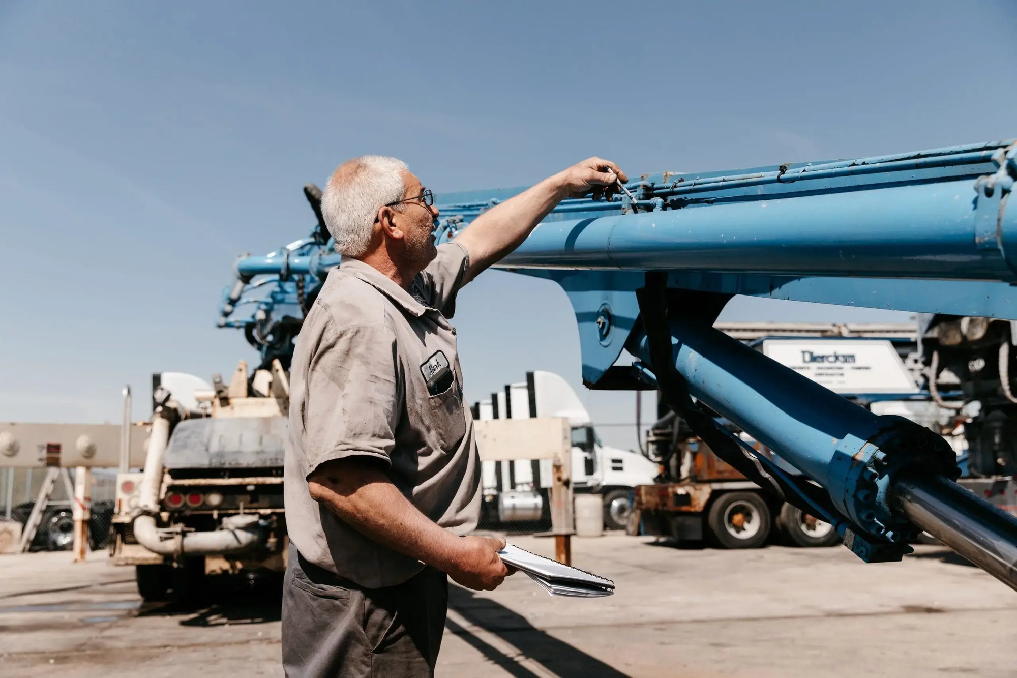 Mark Kelemen wearing a gray shirt and black trousers, inspecting a boom