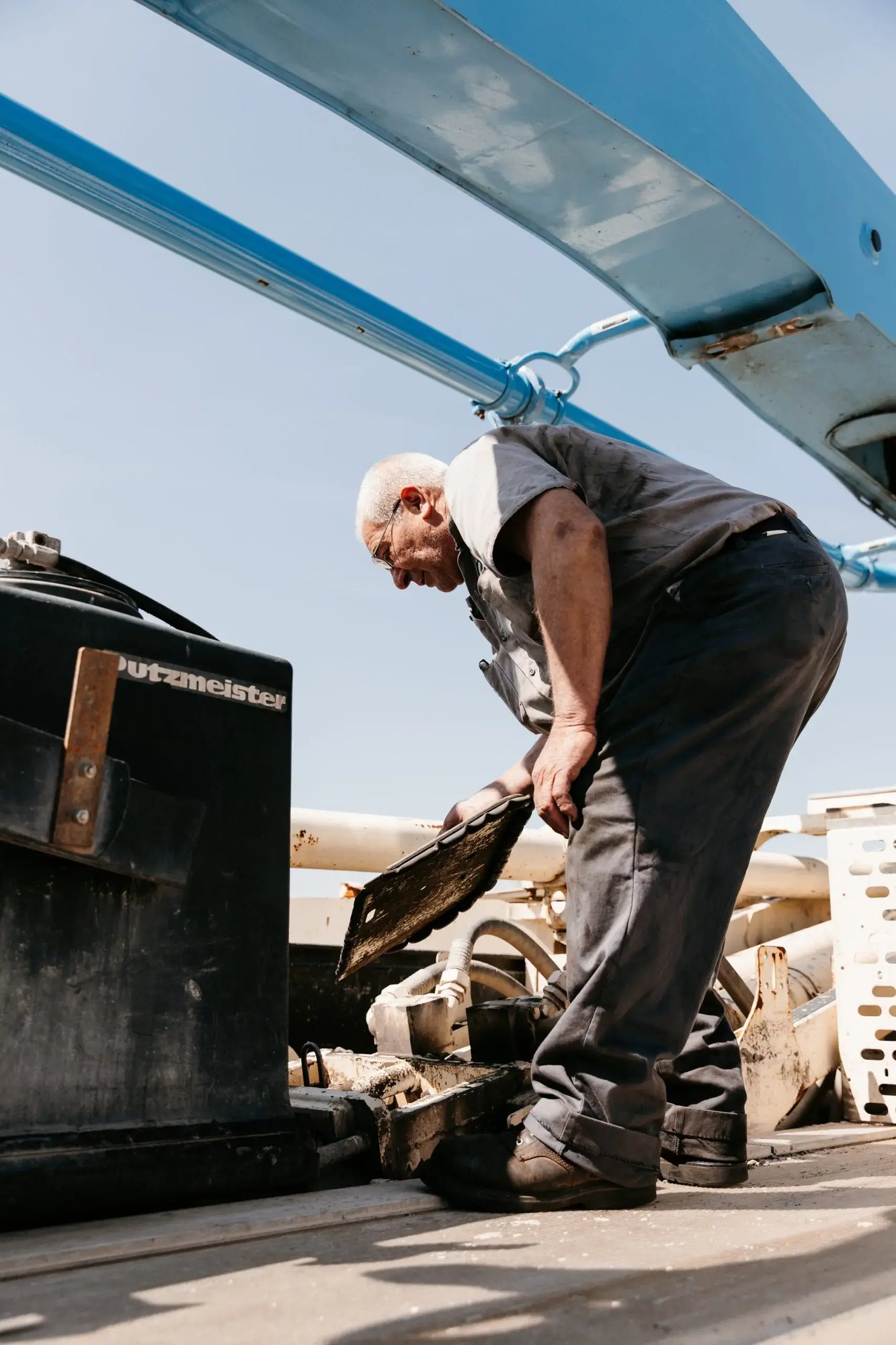 Mark Kelemen leaning down to inspect equipment as part of a boom inspection