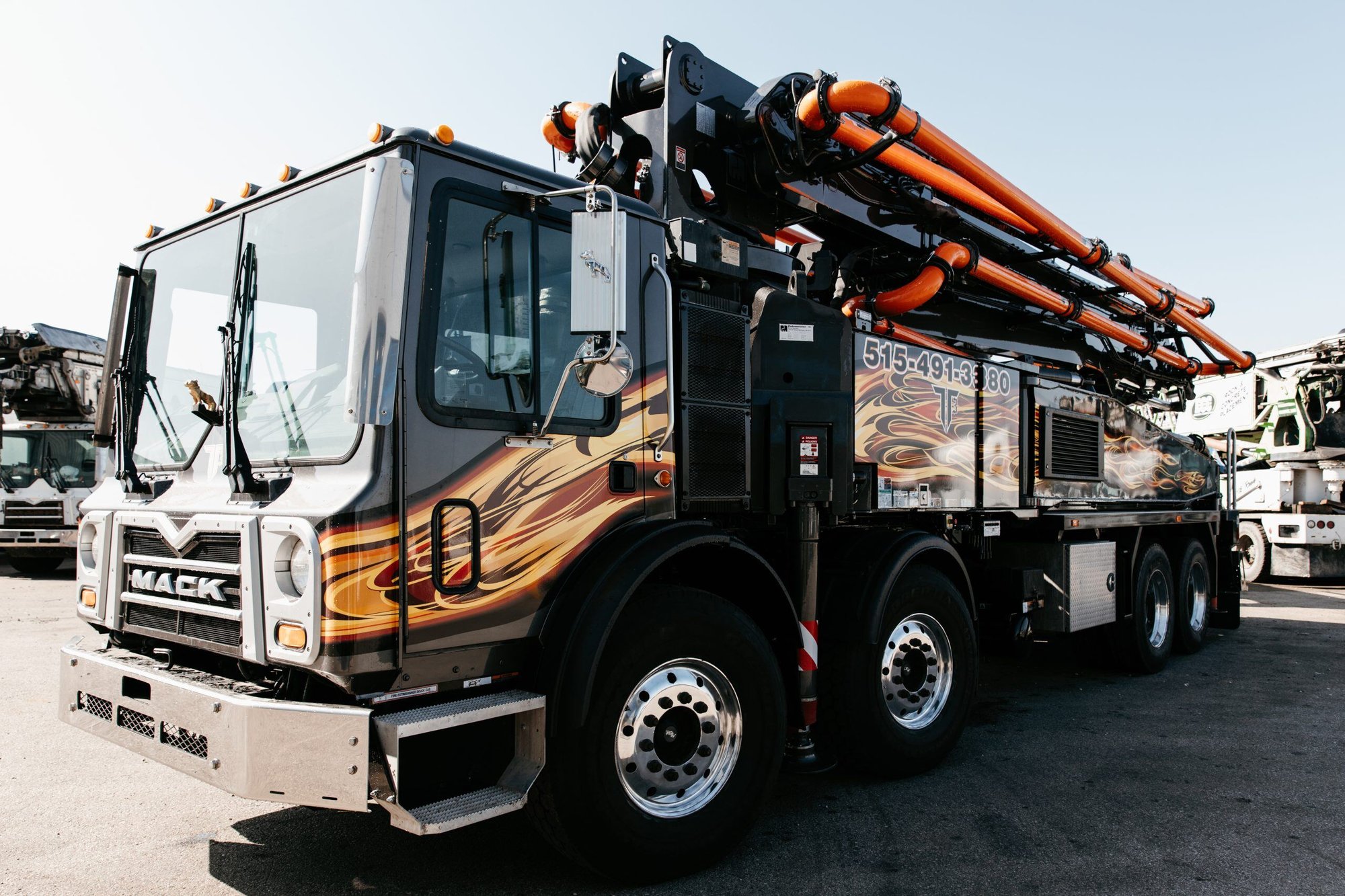 A refurbished Putzmeister concrete pump mounted on a black Mack chassis