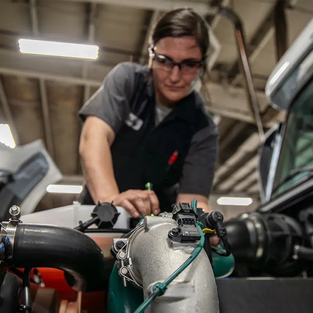 A Kriete technician in a dark gray shirt servicing an engine