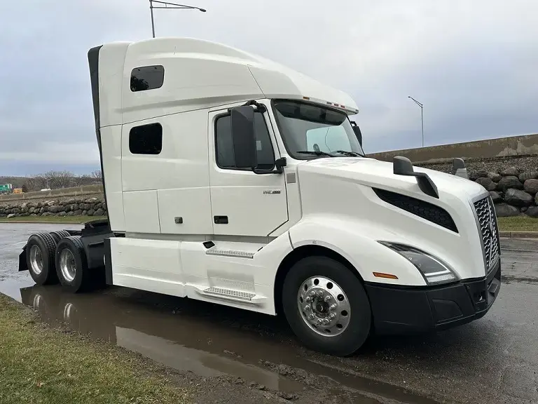 Off-white Volvo VNL truck on a wet road