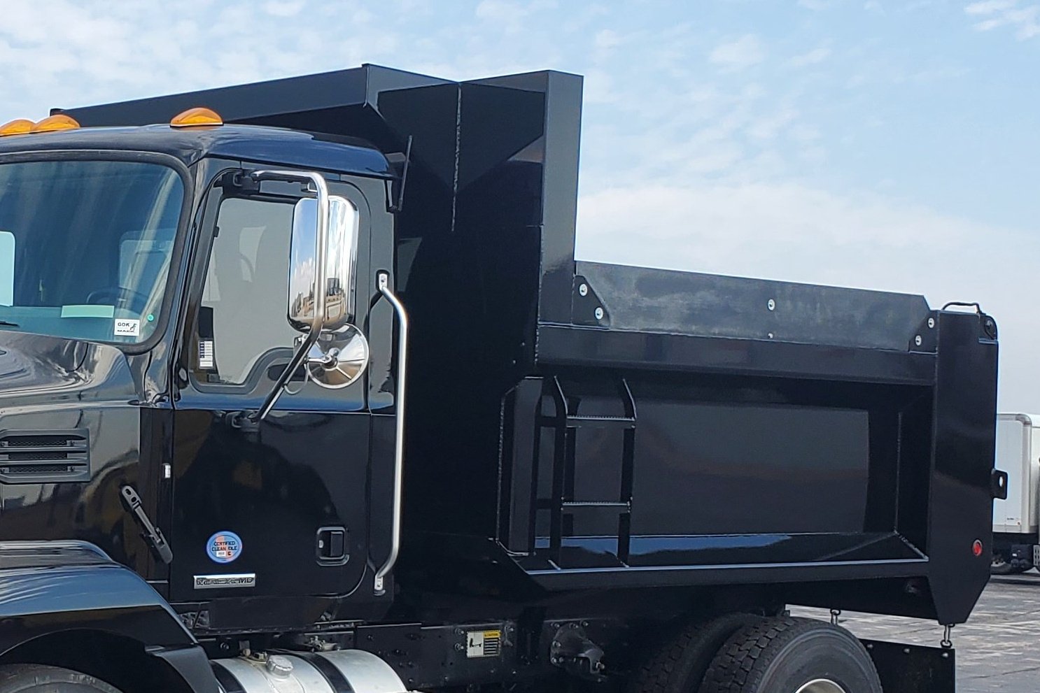 A black Cross Country CCMD dump body with straight gate on a black truck