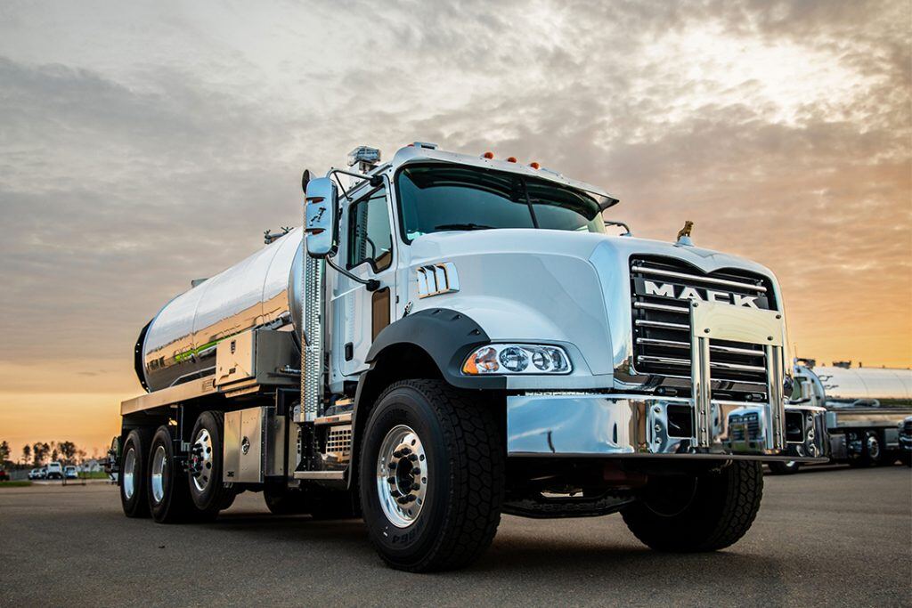 Granite Mack truck beneath a pale sunset